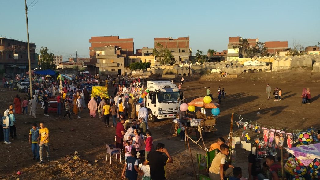 صورة بين أحضان المقابر.. أهالي قرى مركز دمنهور يحتفلون بعيد الأضحى بالبلالين